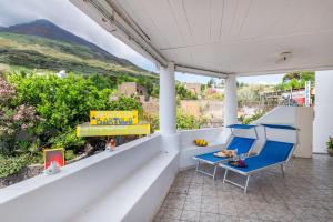 un portico con due sedie e un tavolo e una vista di Stromboli Suite Apartment with Terrace Volcano & Sea view a Stromboli