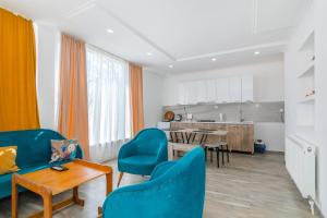a living room with blue chairs and a table at Guest House Check in Borjomi in Borjomi