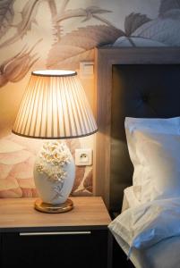 a lamp sitting on a table next to a bed at La Maison Charentonneau in Maisons-Alfort