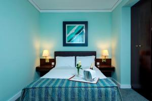 a hotel room with a bed with a tray with a kettle at Hotel Apartamento Solverde in Espinho