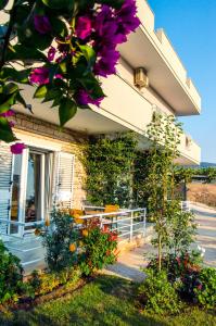 ein Gebäude mit lila Blumen davor in der Unterkunft Villa Paja in Ksamil