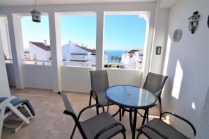 balkon ze stołem i krzesłami oraz oceanem w obiekcie Edf Fuentes A 2G - Eurosur w mieście Nerja