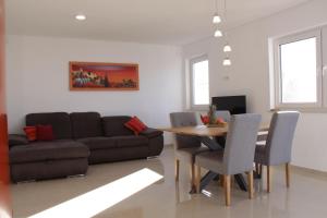 a living room with a couch and a table and chairs at Aparthotel Dalmacija in Privlaka