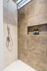 a bathroom with a shower with two bottles at The Wave in Canggu