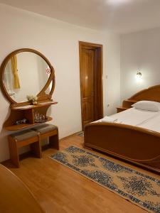 a bedroom with a bed and a large mirror at Pensiunea Ana in Baile Felix