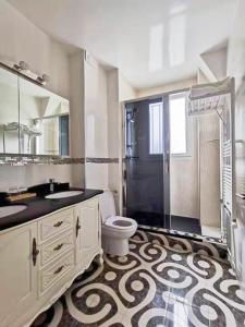 a bathroom with a toilet and a sink and a shower at La Maison Charentonneau in Maisons-Alfort