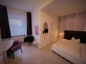 a bedroom with a bed and a desk and a chair at Arena Hotel in Gelsenkirchen