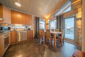 a kitchen with a table and chairs and a large window at Levillas Kinnastie 35 Villas in Levi