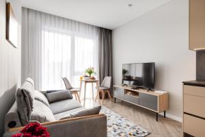 a living room with a couch and a tv at #stayhere Modern & Compact 1BDR Uptown Vilnius in Vilnius