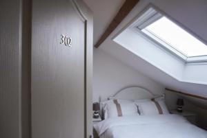 a bedroom with a bed and a window at La Maison Charentonneau in Maisons-Alfort