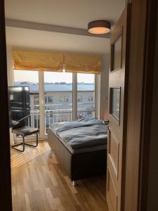 a bedroom with a bed and a large window at Stilvolle Ferien-Geschäftswohnung Brandenburger Seenlandschaft in Werder