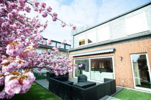 a house with a flowering tree in front of a building at Hotel Am Sportpark in Duisburg