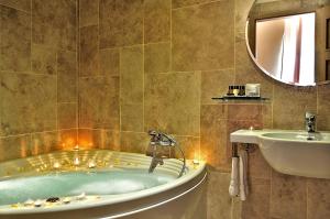 a bathroom with a tub, sink, mirror and bathtub at Hotel Le Clarisse al Pantheon in Rome