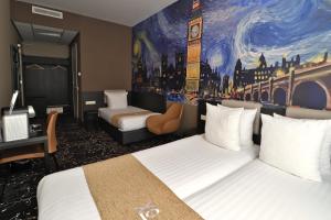a hotel room with two beds and a painting on the wall at Hotel Van Gogh in Amsterdam