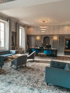 a living room with couches and a grand piano at Le Champlain in La Rochelle