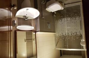 baño con 2 lavabos y ducha de cristal en Marmaris Hotel Apartments, en Amán