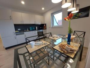 a kitchen with a dining table and a kitchen with white cabinets at Ferienwohnung Helenenquelle in Bad Wildungen