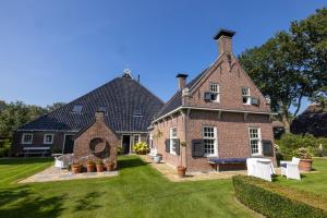 a large brick house with a grass yard at de Buwepleats in Drogeham