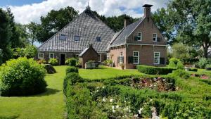 an old house with a garden in front of it at de Buwepleats in Drogeham