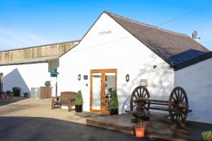 a white building with a bench in front of it at St Ronans Cottages in Duffstown
