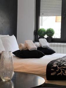a bed with black and white pillows and a window at Apartment Story,Kajmakcalanska Beograd in Belgrade