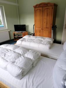 a group of white beds in a room at Ferienwohnung 1, Waldesruh Dierhagen in Dierhagen