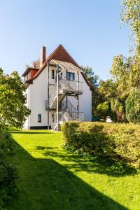 a large white house with a staircase on it at Ferienwohnung 1, Waldesruh Dierhagen in Dierhagen