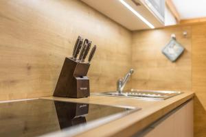 eine Küchentheke mit einem Messerblock neben einer Spüle in der Unterkunft Ciasa Rungg App Pares in St. Vigil + 21 Fotos
