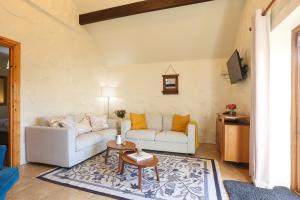 a living room with two couches and a table at St Ronans Cottages in Duffstown
