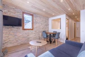 - un salon avec un canapé et une table dans l'établissement Résidence Le Val d'Illaz - Val-d’Isère, à Val dʼIsère