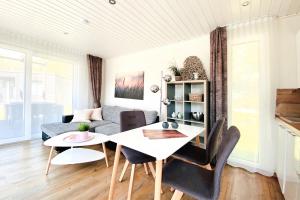 ein Wohnzimmer mit einem Tisch und einem Sofa in der Unterkunft Gronenberger Mühle Haus 21 in Scharbeutz