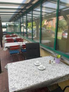 a dining room with a table and chairs and windows at Schiffspension Luise in Potsdam