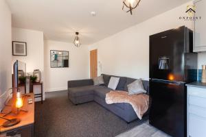uma sala de estar com um sofá e um frigorífico em Modern 3-Storey House With Free Parking! em Birmingham