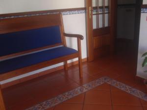 un banc en bois posé sur un sol carrelé à côté d'une porte dans l'établissement Residencial Idalio, à Odemira