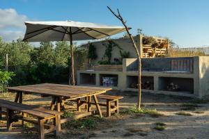 una mesa de picnic con una sombrilla junto a un edificio en Casa de campo mediterránea en Alicante, en Agost