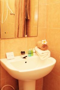 y baño con lavabo, espejo y toallas. en Odani Villa, en Weligama