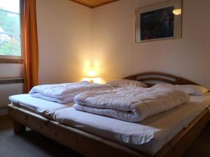 Una cama con sábanas blancas y almohadas. en Ferienhaus Seeadler, en Userin