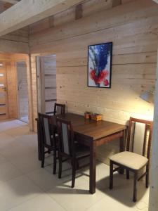 a dining room with a wooden table and chairs at Dom z bala Dar Lasu in Szczytno