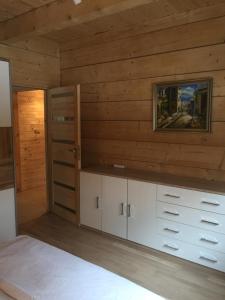 a room with white cabinets and a wooden wall at Dom z bala Dar Lasu in Szczytno