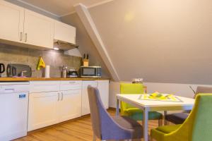 - une cuisine et une salle à manger avec une table et des chaises dans l'établissement Pension & FeWo's Talblick, à Weitersglashütte