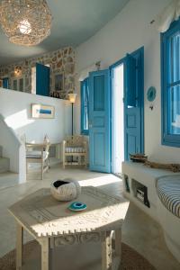 a living room with blue doors and a table at Villa Mikros Vorias in Karavostasi