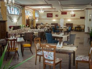 a restaurant with tables and chairs in a room at Hotel Palas in Kazanlŭk