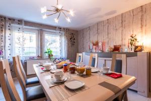a dining room with a wooden table and a kitchen at Flopre in Flocourt