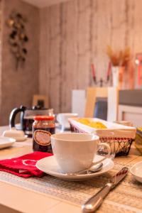 einen Tisch mit einer Tasse und einem Teller Essen in der Unterkunft Flopre chambre d'hote in Flocourt