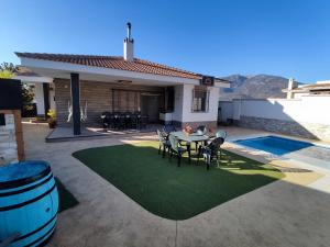 a patio with a table and chairs next to a house at Villa Campoamor in Los Villares