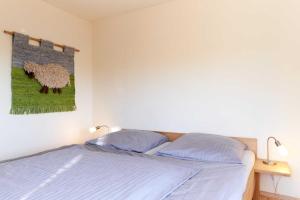 a bedroom with a bed and a painting of a sheep at Seestern in Nordstrand
