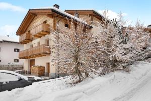 ein Haus mit Schnee auf dem Boden davor in der Unterkunft Casa Nicoletta inverno in Livigno