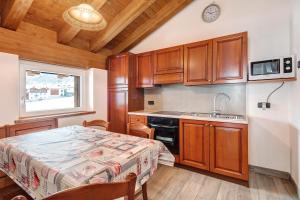 a kitchen with wooden cabinets and a table and a sink at Casa Nicoletta inverno in Livigno