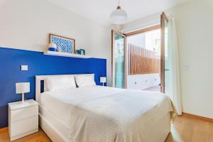 - une chambre avec un lit blanc et un mur bleu dans l'établissement Gelman's Getaway in Lisbon, à Lisbonne