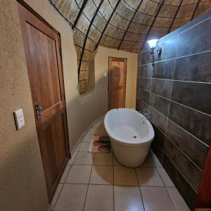 a bathroom with a tub and a toilet in a room at Mountain Aloe Den in Barberton